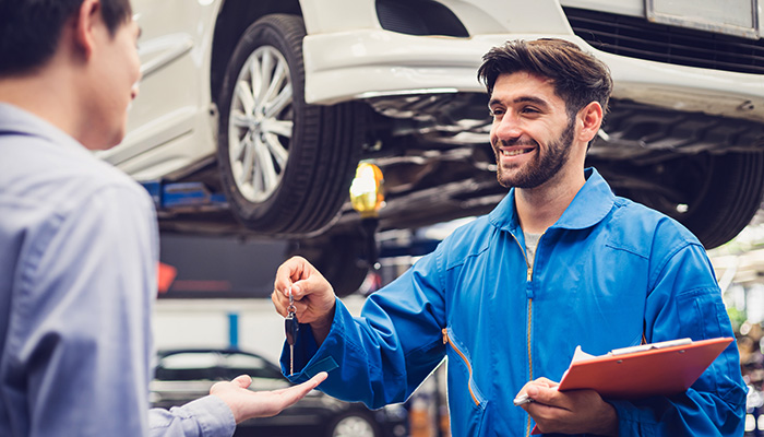 GMC service technician assisting customer during vehicle maintenance appointment