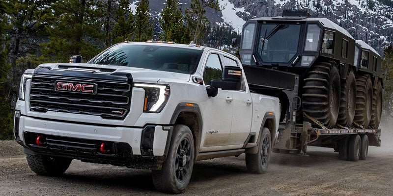 2026 GMC Sierra 2500 HD heavy-duty pickup truck driving on a rugged off-road trail