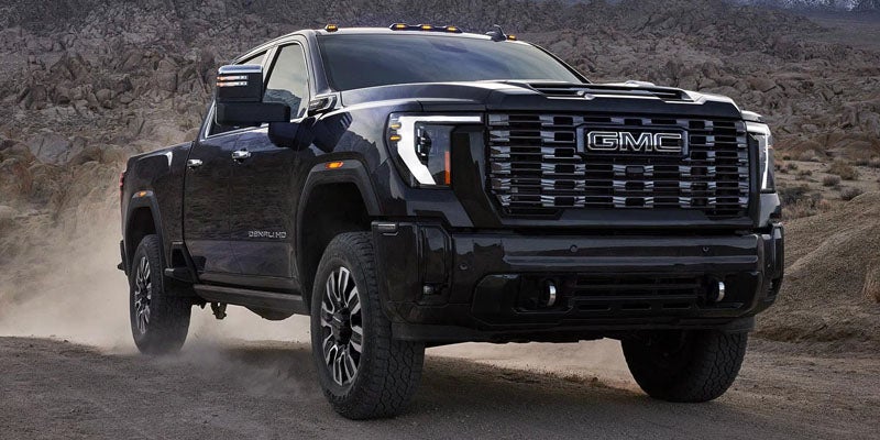 Front three-quarter view of the 2026 GMC Sierra 2500 HD driving on a road
