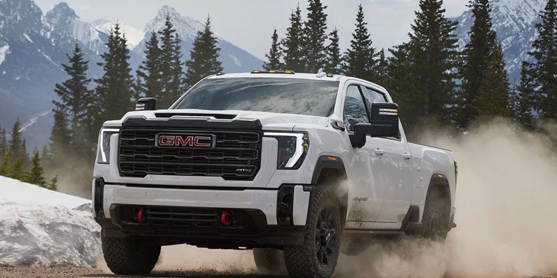 2026 GMC Sierra 2500 HD driving on a dirt road with confidence