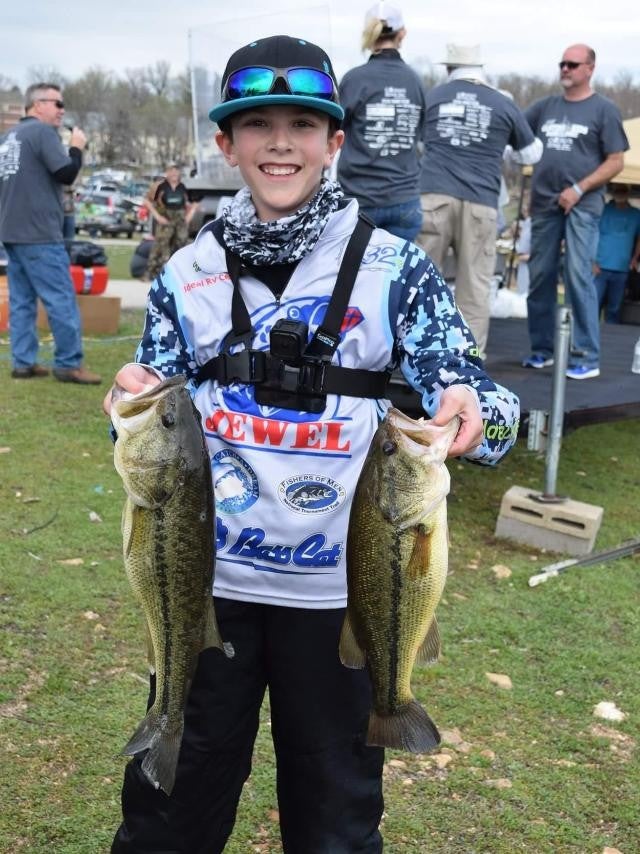 young boy holding two finsh in hand